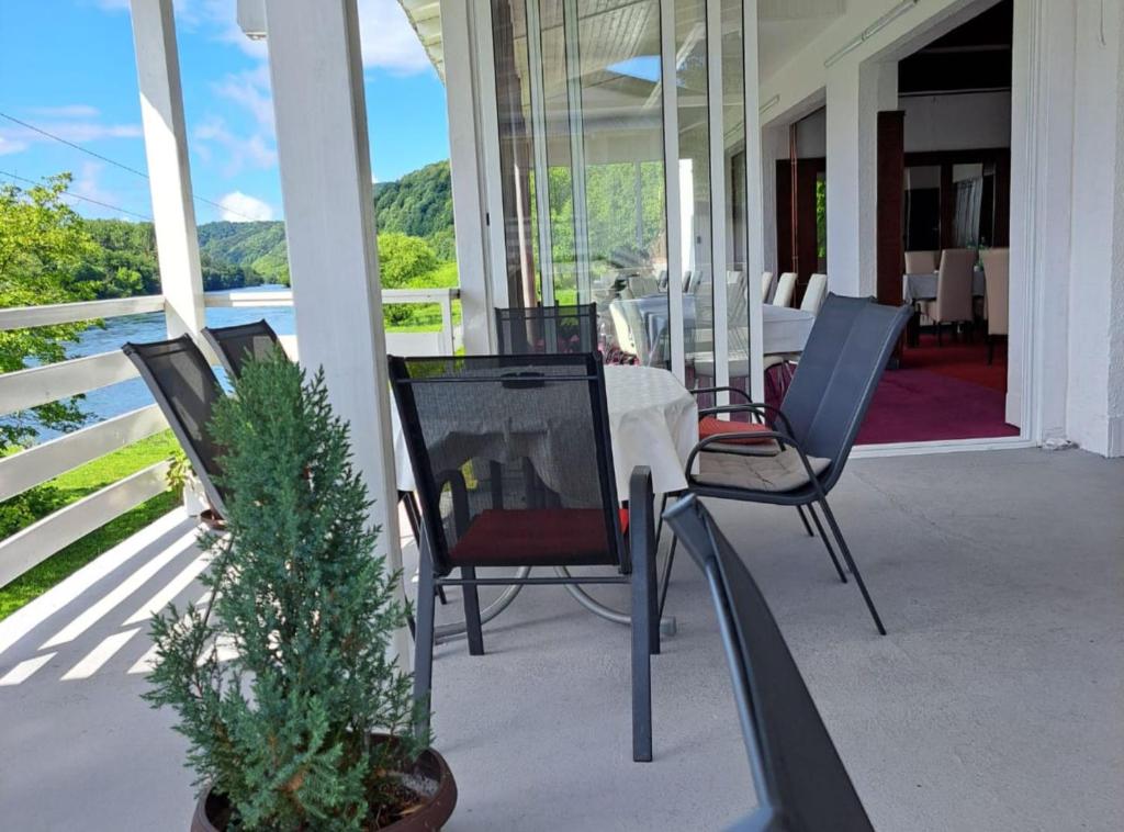 a porch with chairs and a table and a christmas tree at Rooms Đenadija in Hrvatska Kostajnica