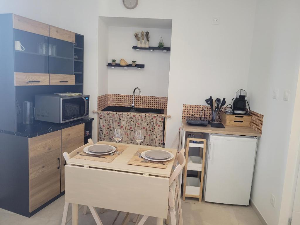 a small kitchen with a table and a sink at Le cocon de Suze in Suze-la-Rousse
