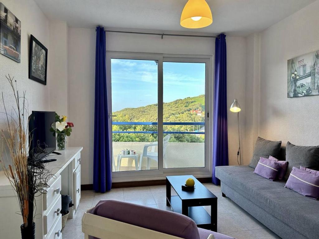 a living room with a couch and a large window at Duplex con vistas La Arena 4605 in Arnuero