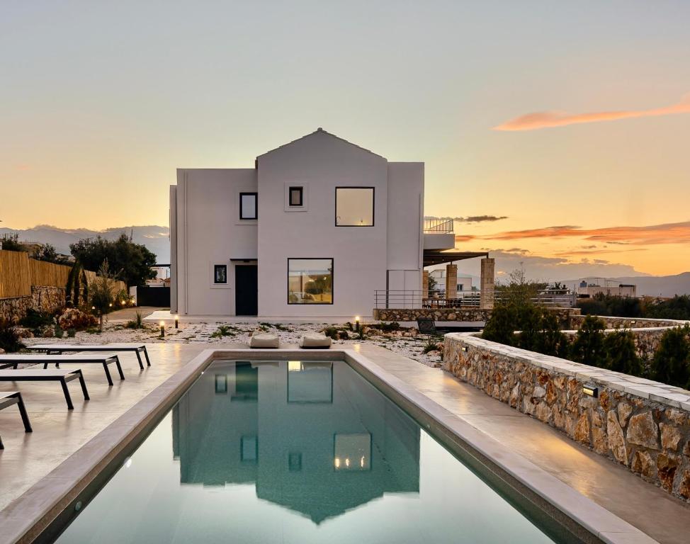 a villa with a swimming pool in front of a house at Plaka Oasis - Private Pool - Walk to Beach & Shops in Plaka