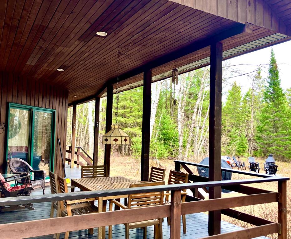 a screened in porch with a table and chairs at Le Domek de nature apaisante in Sainte Béatrix