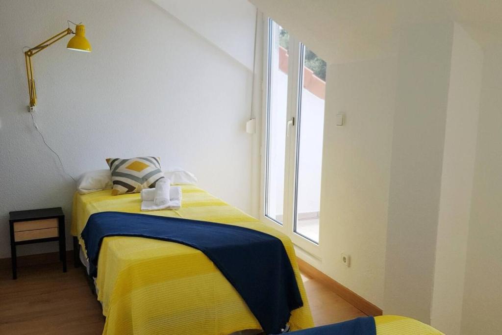 two beds in a room with a window at La Arena 4410 in Isla