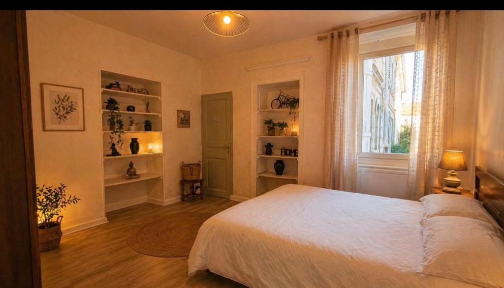 a bedroom with a white bed and a window at Le Jasmin in Lure