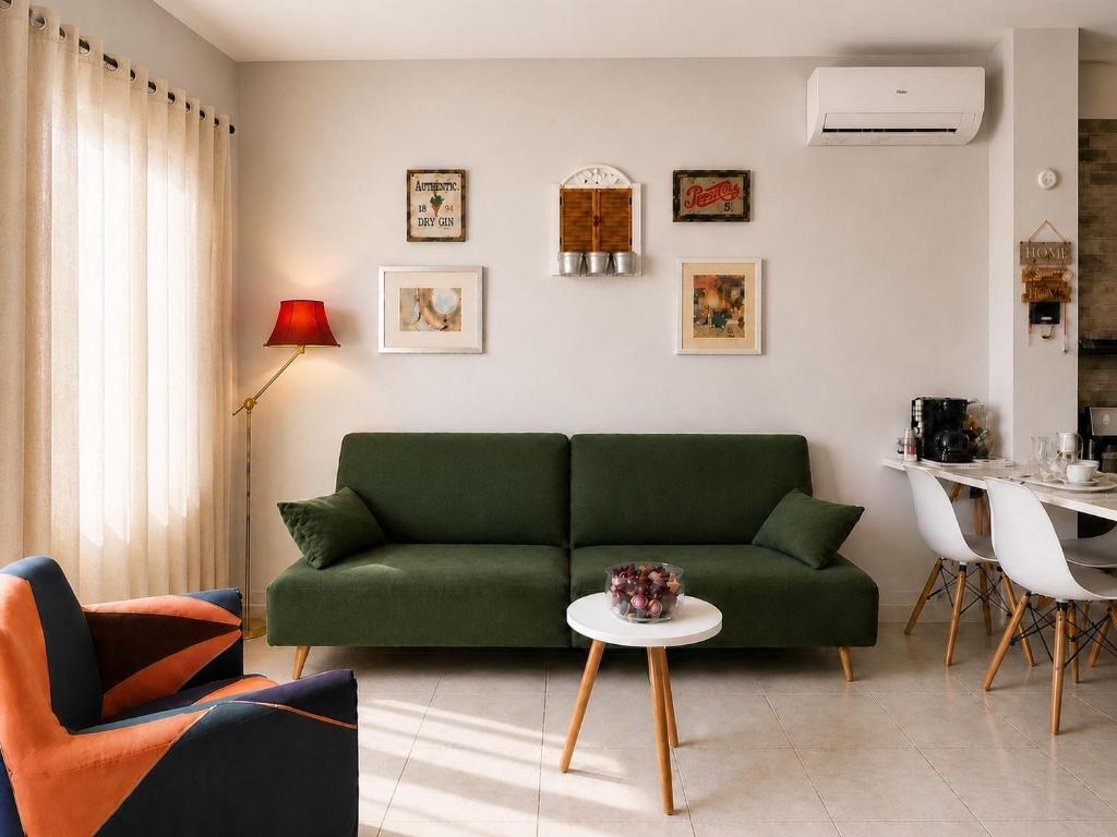 a living room with a green couch and a table at Petit house Vrachati in Vrachati
