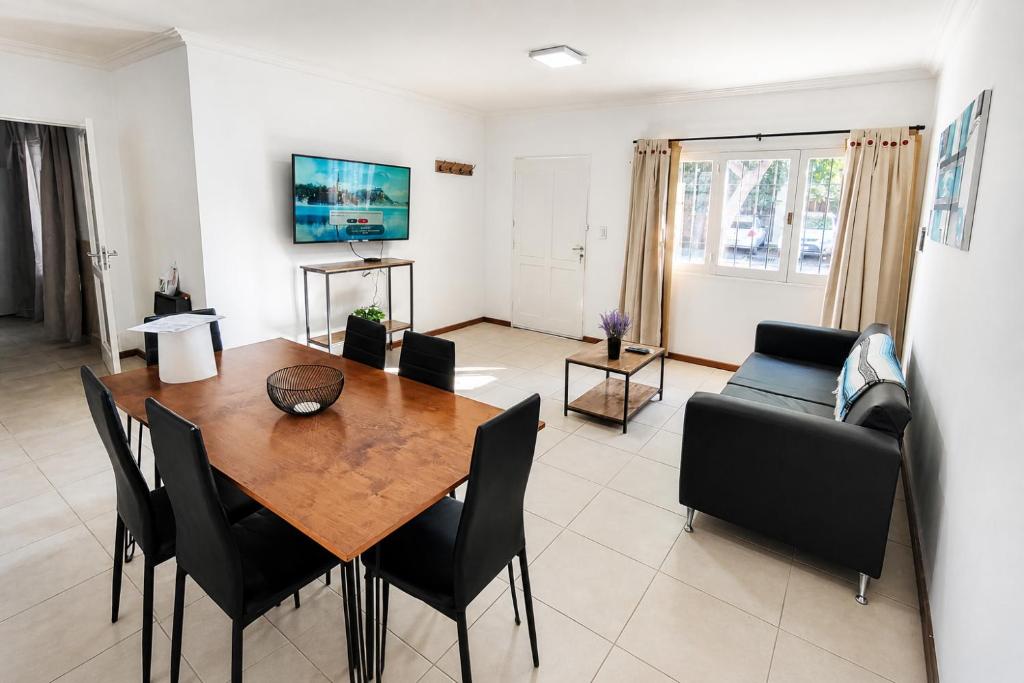 a living room with a wooden table and black chairs at JACARANDA - Alojamiento vacacional in Godoy Cruz