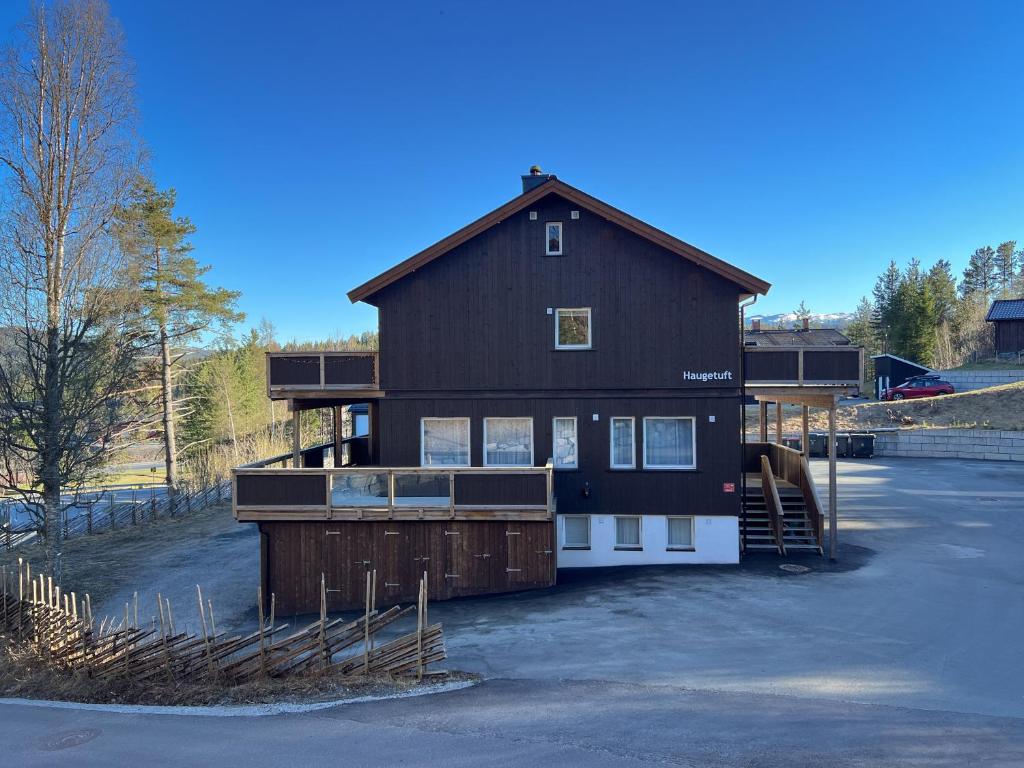 a large black house with a gambrel at Haugetuft Apartments in Åmot