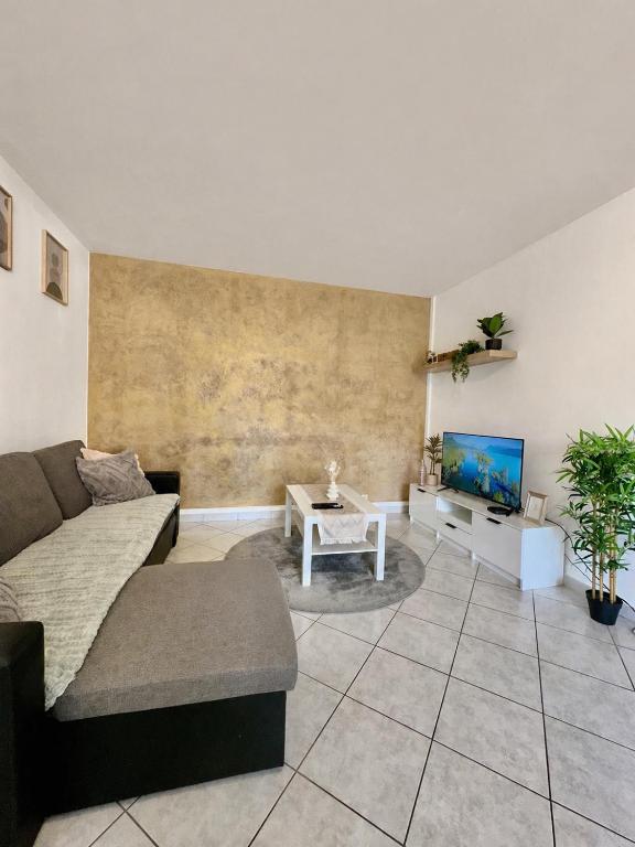 a living room with a couch and a tv at T2 Evry Centre - Proche de Orly et Paris in Courcouronnes