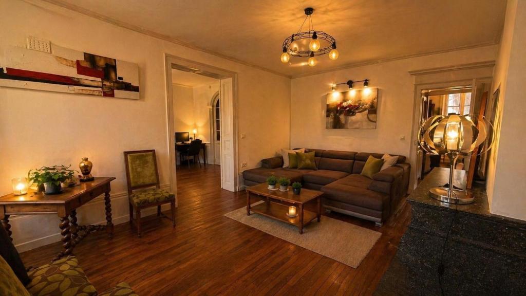 a living room with a couch and a table at Les jardins d'Elise in Lure