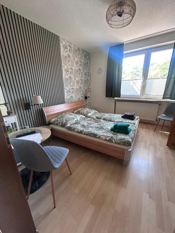 a bedroom with a bed and a desk and a chair at Gästehaus Gute Quelle in Cochem