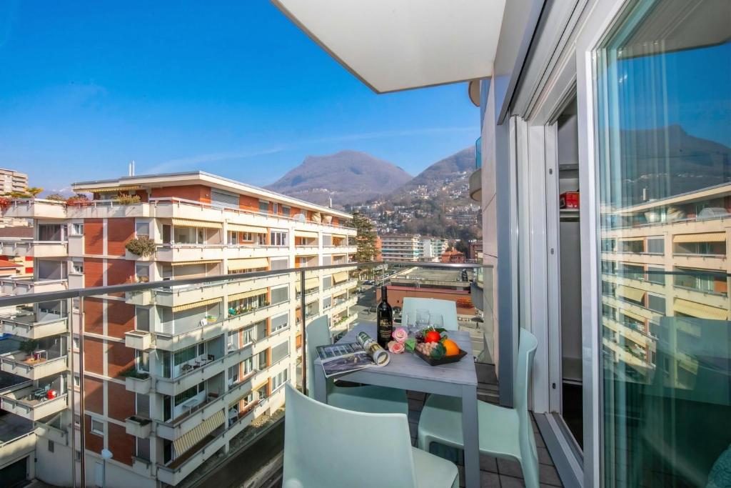 a balcony with a table and chairs and a view of buildings at Via al Chioso in Lugano