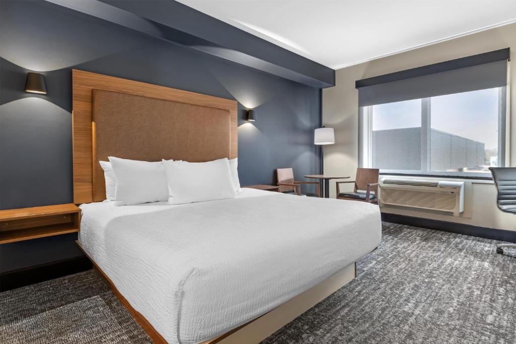 a hotel room with a large bed and a window at Best Western Plus Neepawa Hotel in Neepawa