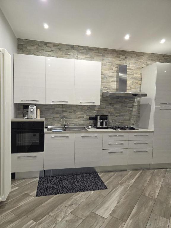 a kitchen with white cabinets and a stove top oven at Living Monza Arengario in Monza