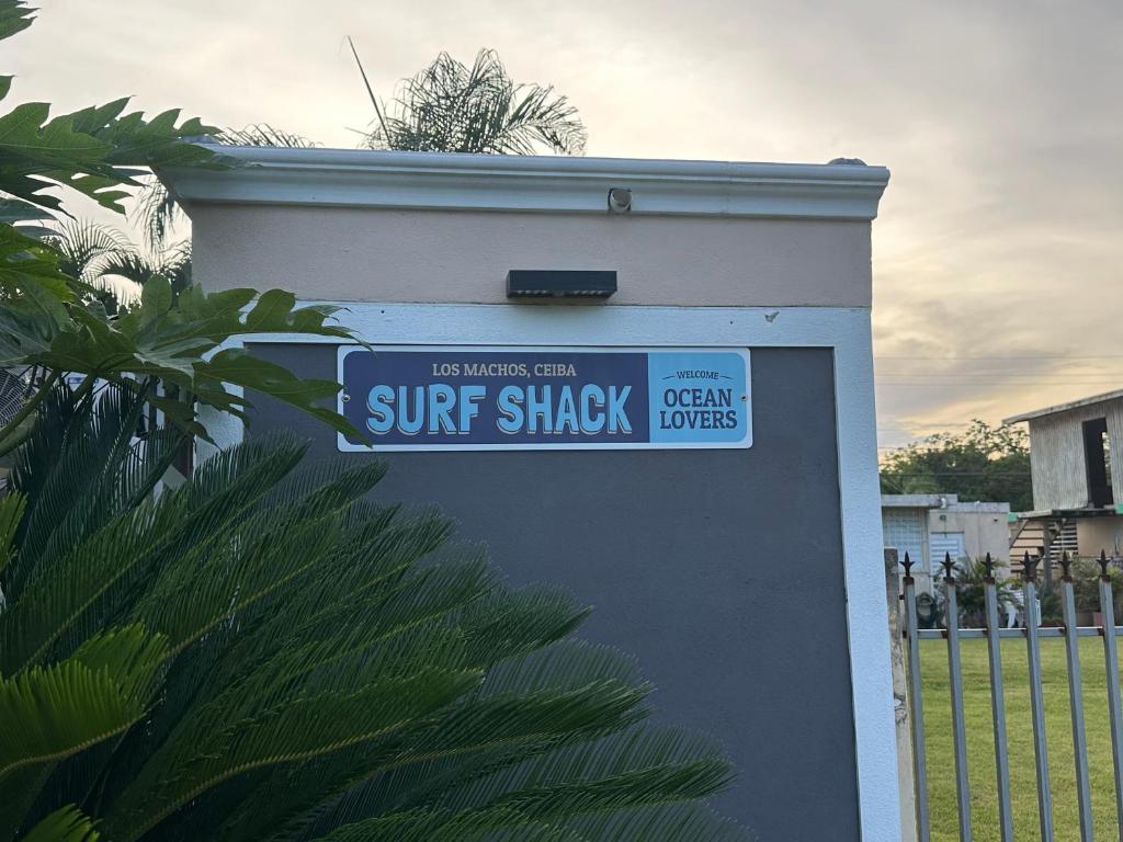 a street sign for a surf shack on a wall at Los Machos surf shack in Ceiba