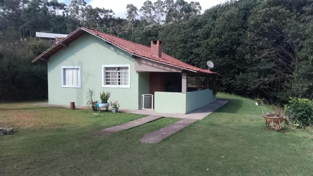 a small white house with a grass yard at Sítio jaguary in Camanducaia
