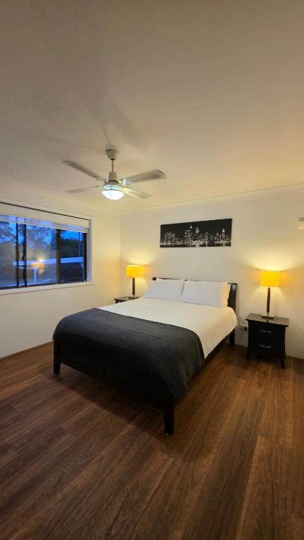 a bedroom with a bed and a ceiling fan at Spacious & Sun-Filled Highlands Retreat in Moss Vale