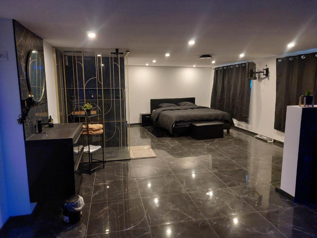 a bedroom with a bed and a bathroom with a sink at Suite Privée Deluxe O'Palawan Gold PROCHE TOURCOING CENTRE in Tourcoing