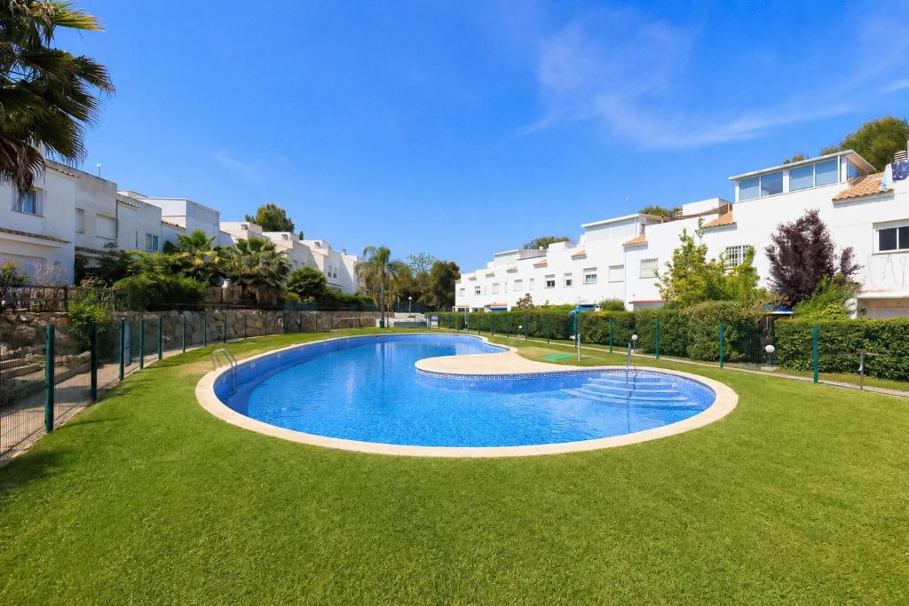 a swimming pool in the middle of a grass field at Cumbre in Salou