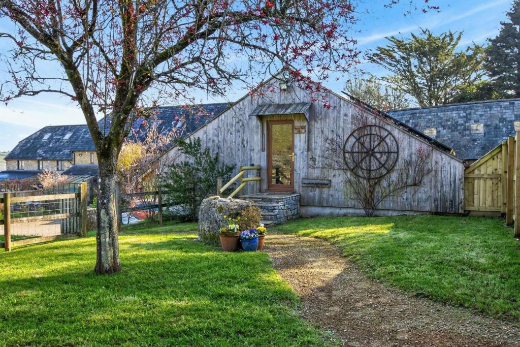 an old barn with a tree in the yard at 2 Bed in Beaminster oc-63047 in Broadwindsor