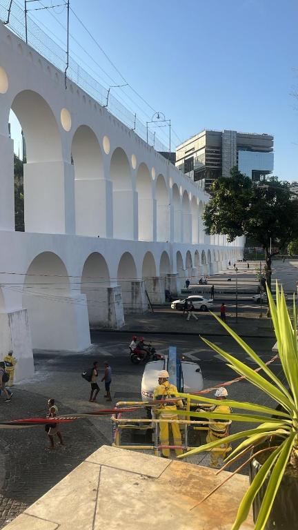 a bridge with people walking around in a parking lot at Arcos Da Lapa Hostel in Rio de Janeiro