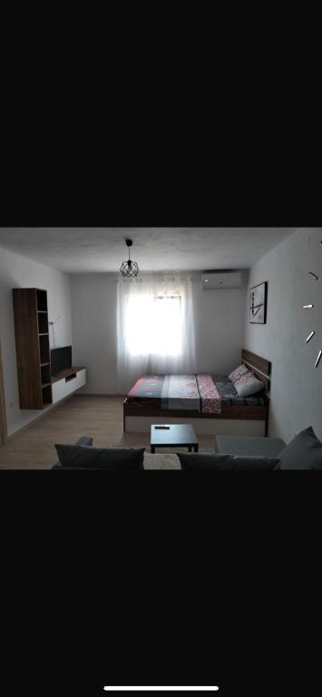 a room with a bedroom with a bed and a window at Talic Apartmani in Sutomore