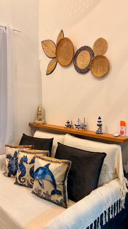 a bed with pillows and hats on the wall at Loft Brisa de Búzios in Búzios