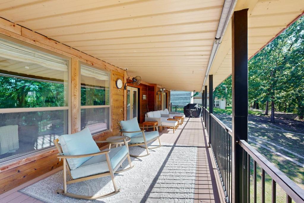 a porch of a house with chairs and tables at Sprawling Eufaula Lake Sanctuary w/ Dock! in Texanna