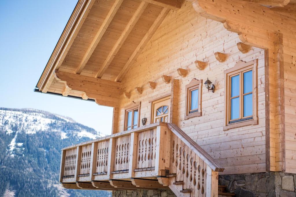 a wooden balcony on a log house with mountains in the background at Steineralm in Schwersberg