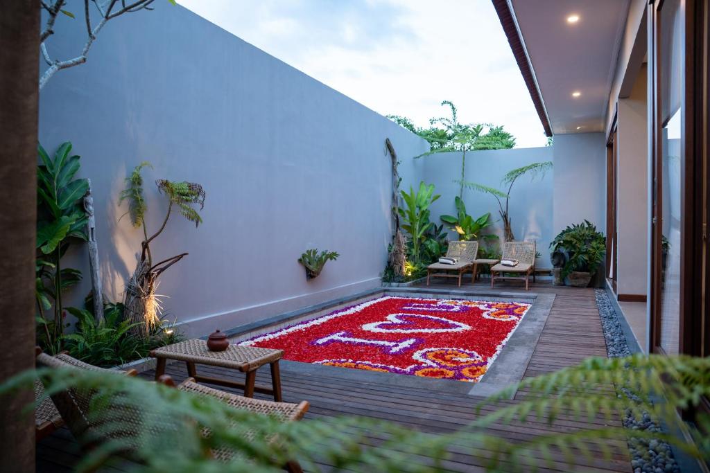 a courtyard with a red rug on a wooden deck at Dahayu Villa Ubud in Ubud