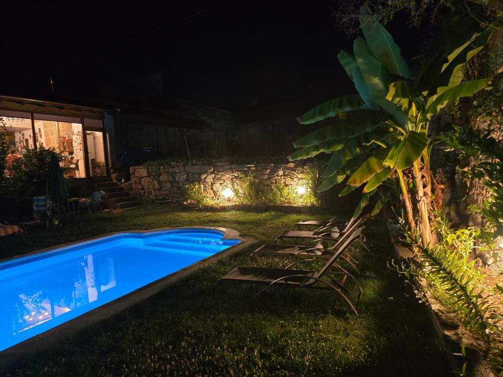 a backyard at night with a swimming pool at Casa a Figueira in Pungín