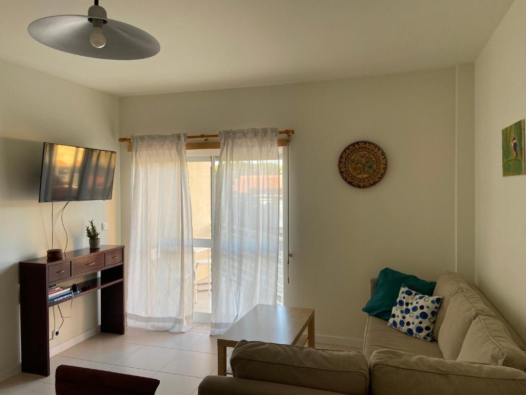 a living room with a couch and a table at Caparica Sol&Mar Apartment in Costa da Caparica