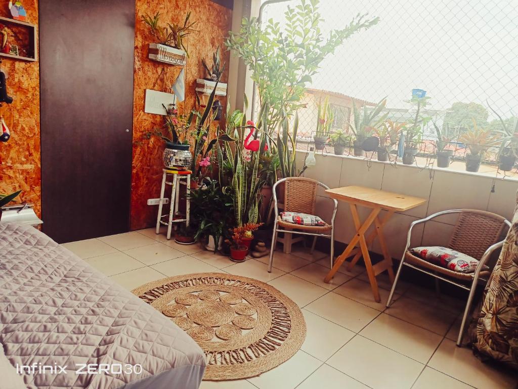 ein Schlafzimmer mit Tisch, Stühlen und Pflanzen in der Unterkunft Villa de María in Guayaquil