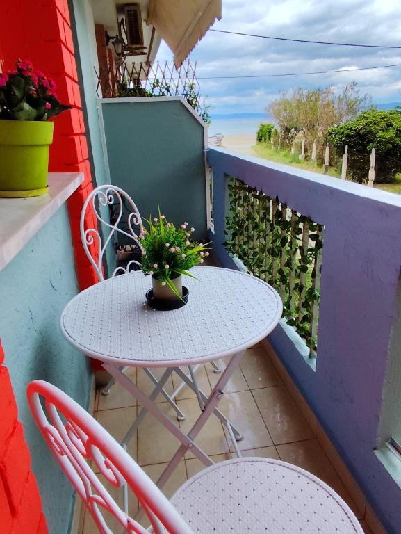 a white table and chairs on a balcony at Sole Di Mare Agia Triada in Agia Triada