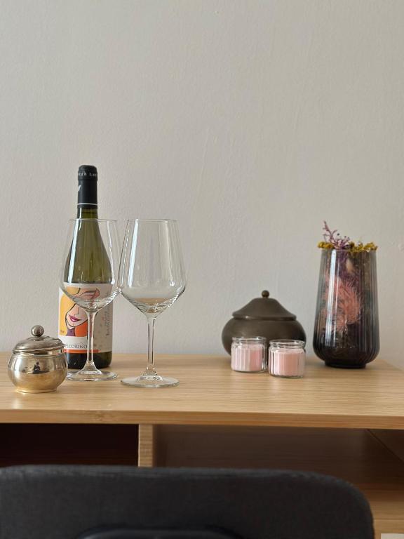 two wine glasses and a bottle on a wooden table at Holidays House Il Vicoletto in Sulmona
