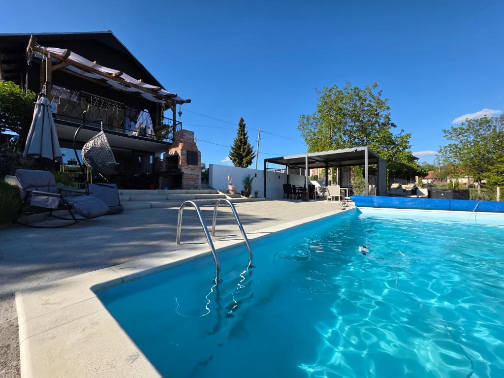 a swimming pool with blue water in front of a house at The Dream house in Tomaš