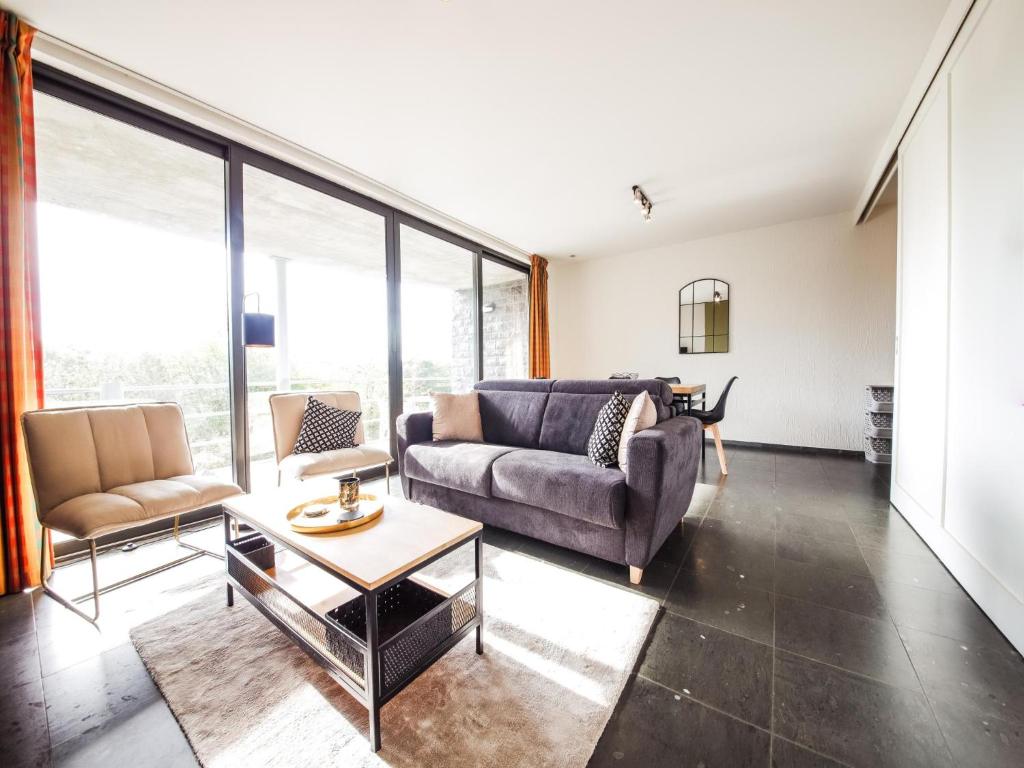 ein Wohnzimmer mit Sofa und Tisch in der Unterkunft Castelgolf in Barvaux