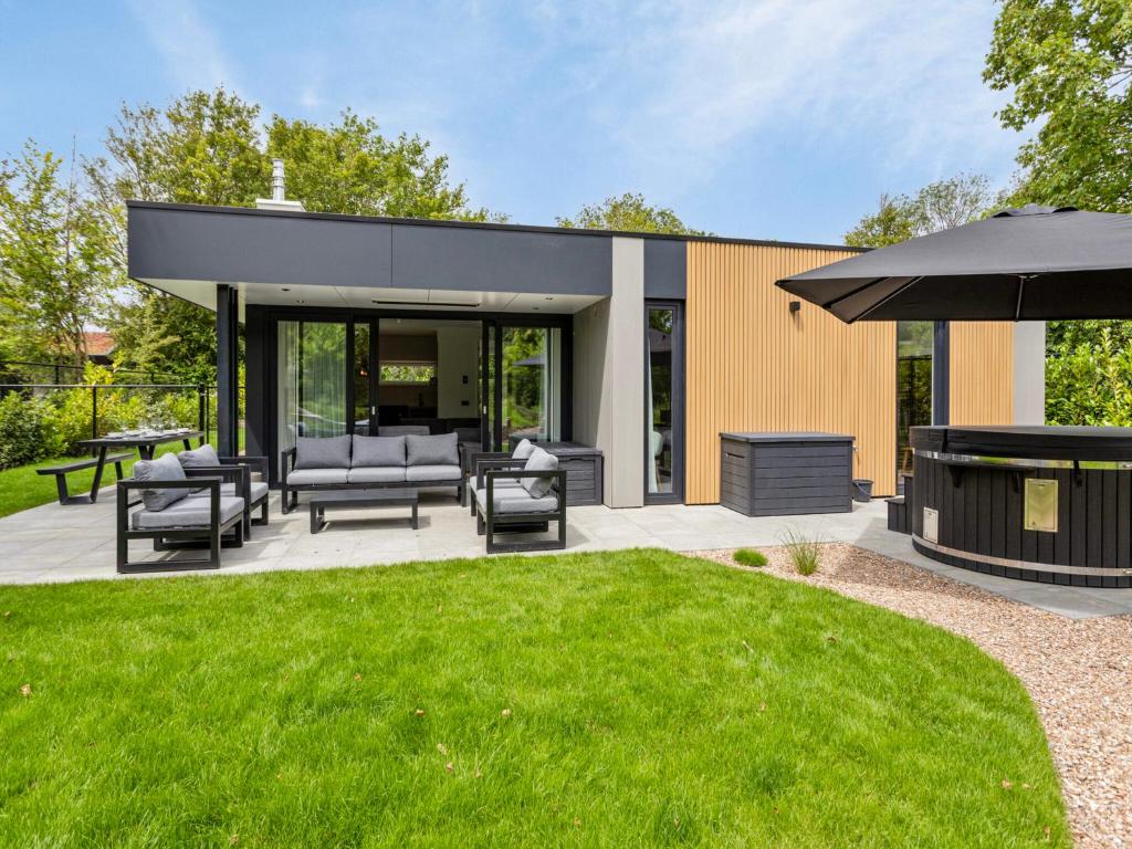an outdoor patio with a grill and lawn at Het Duinnest in Kamperland