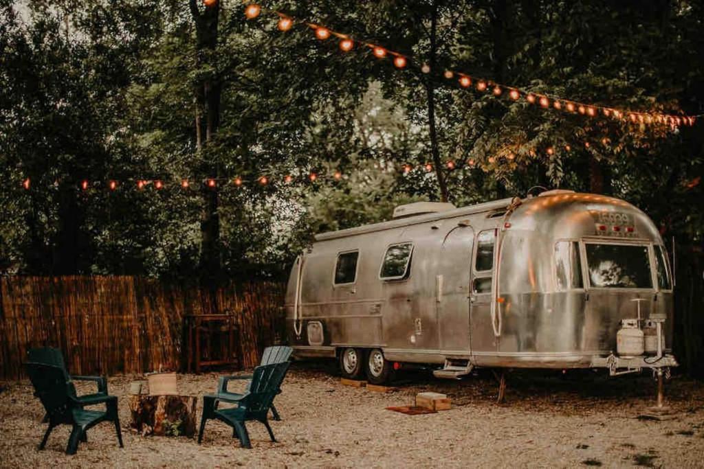 an old airstream trailer parked under a string of lights at Urban Airstream Retreat in Memphis