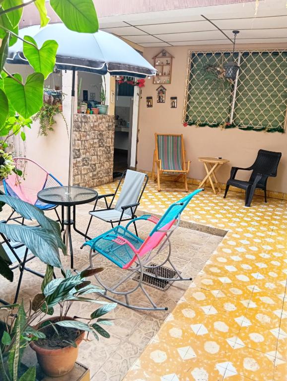 a patio with chairs and a table and an umbrella at Mountain View Hostel in Santa Ana