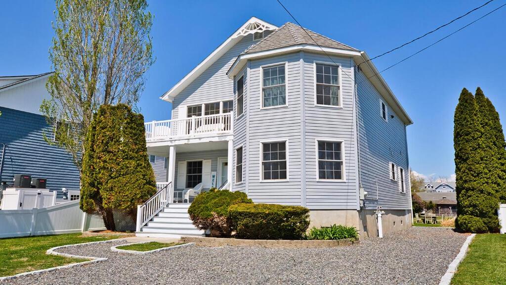 a large white house with a porch and stairs at West Cape Estate in West Cape May