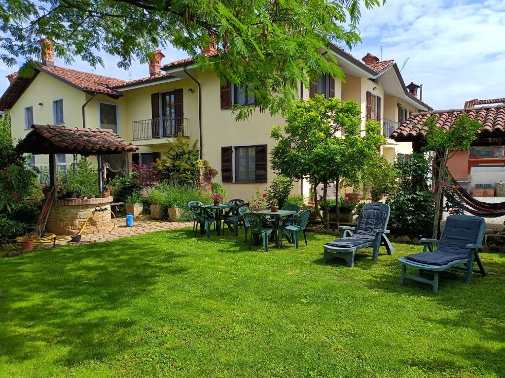 a yard with chairs and tables in front of a house at Casa Vicino in Carrù
