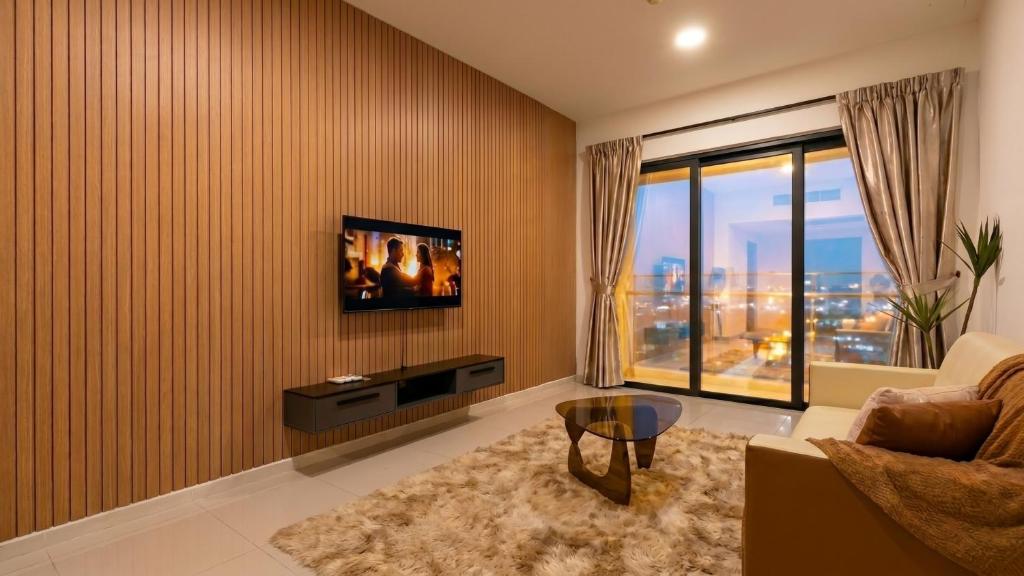 a living room with a couch and a tv on a wall at Suasana JB Central by TPL in Johor Bahru