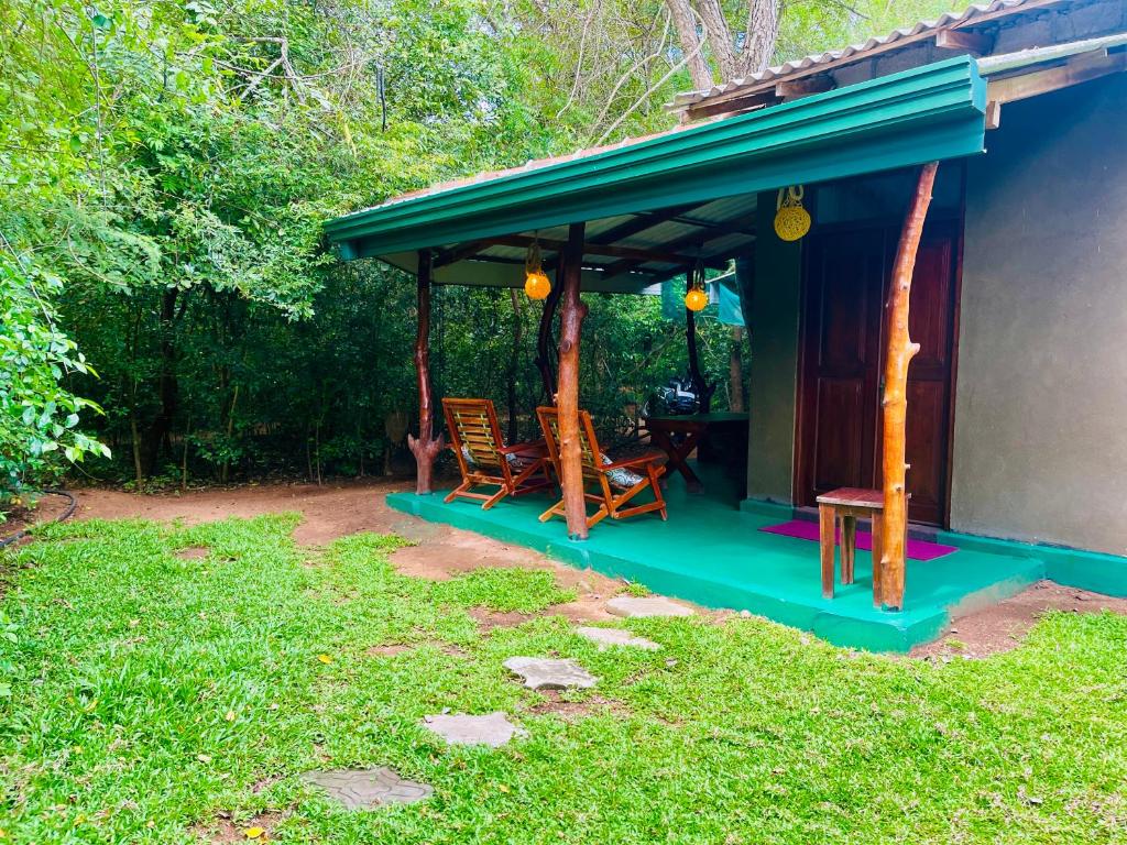 a house with a gazebo with two chairs at Wilpattu Mookalan Resort in Habawewa