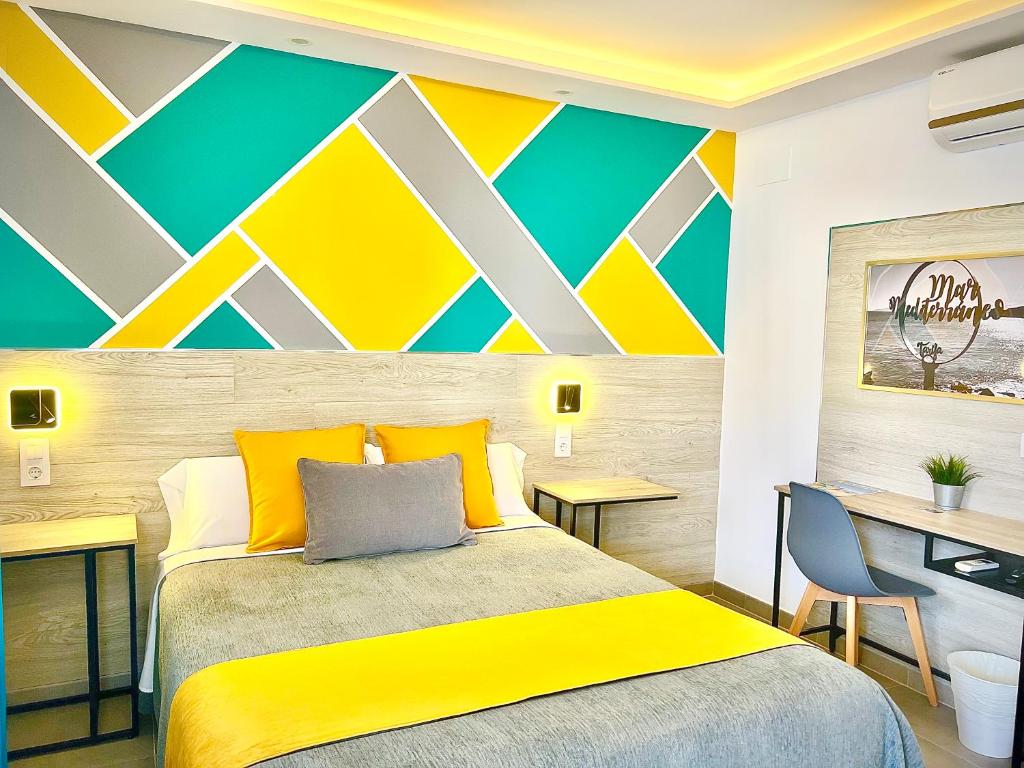 a bedroom with a bed with a yellow and green wall at DORI ROOMS - Hostal in Tarifa
