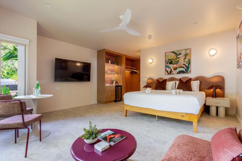 a bedroom with a bed and a living room at CASA AMELIA - Boutique Studio in Port Douglas