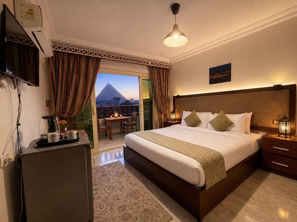 a hotel room with a bed and a large window at Arte Pyramids Hotel in Cairo
