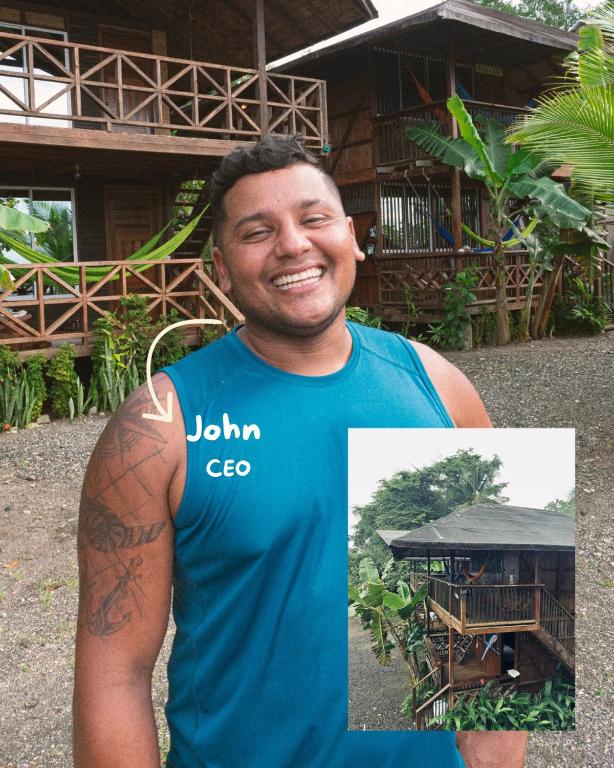a man in a blue shirt standing in front of a house at Ostional River in Arusí