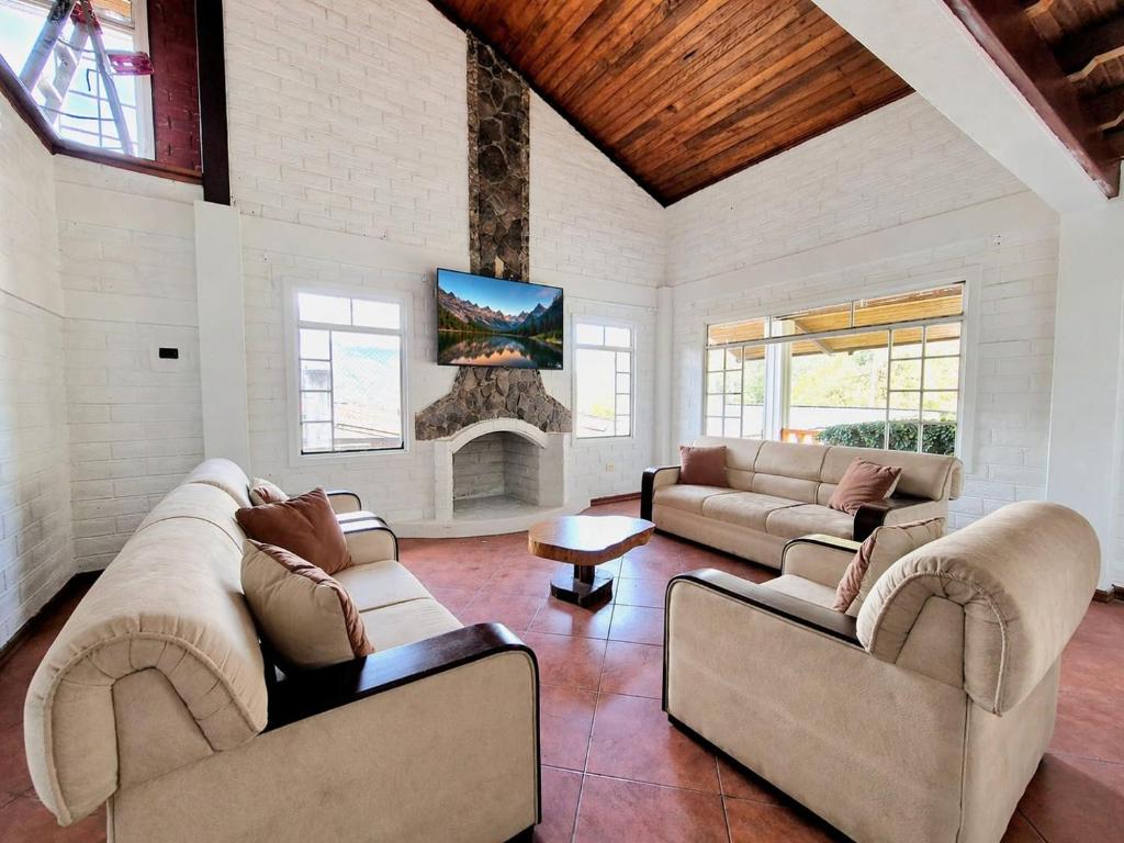 a living room with two couches and a fireplace at Luxury Quinta con Jacuzzi - Sauna - BBQ in Cusúa
