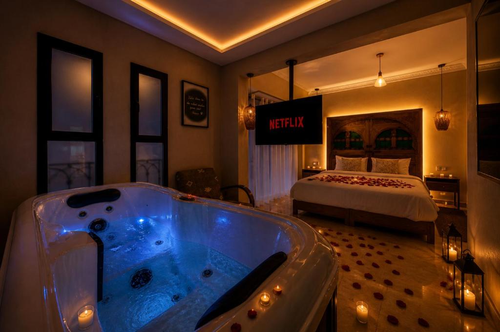 a bathroom with a tub in a room with a bed at Luxury Apartment with Private Jacuzzi & Pool Central Marrakech in Marrakesh