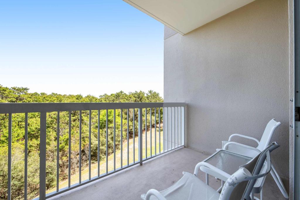 a balcony with two chairs and a railing at Resort Studio with Nature Preserve Views in Destin
