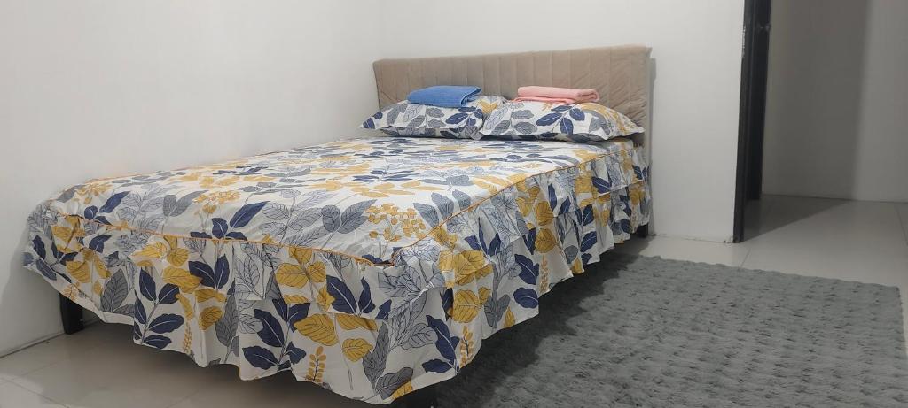 a bedroom with a bed with a blue and yellow blanket at Mike's Staycation in Clark in Angeles